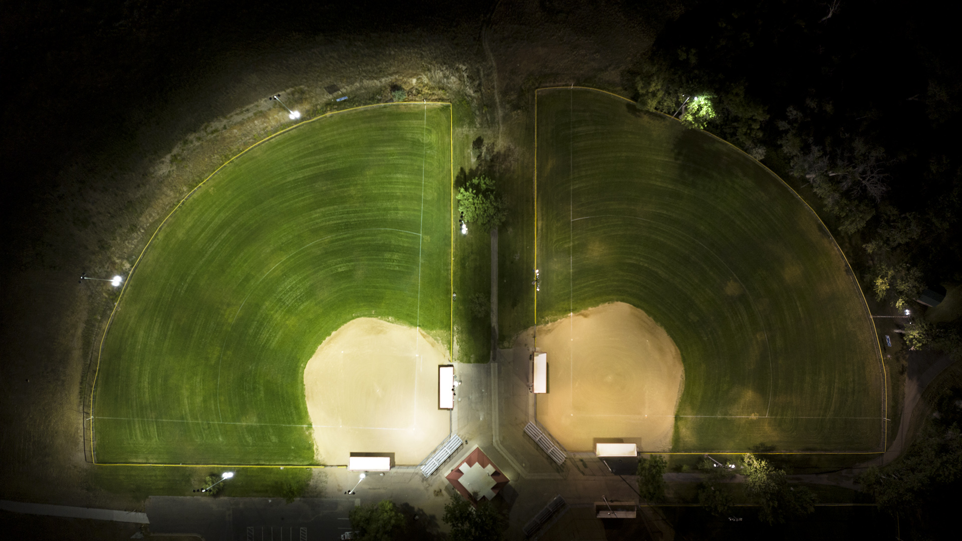 Baseball field on the left is uniformly lit after upgrade to Musco LED sports lighting, versus field with HID lighting on the right.