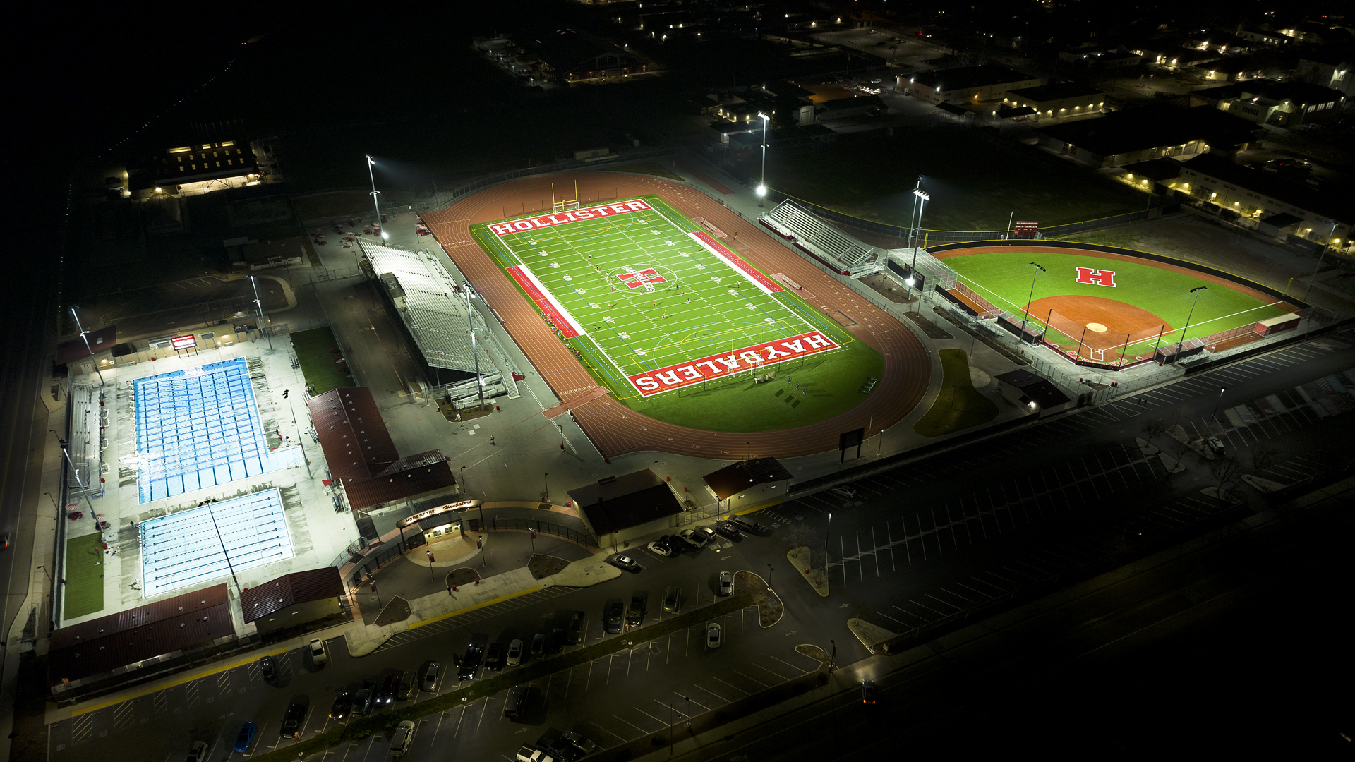 Hollister High School football, baseball, and aquatic center lit at night with minimal light spill and glare to surrounding areas after upgrading to Musco LED sports lighting system