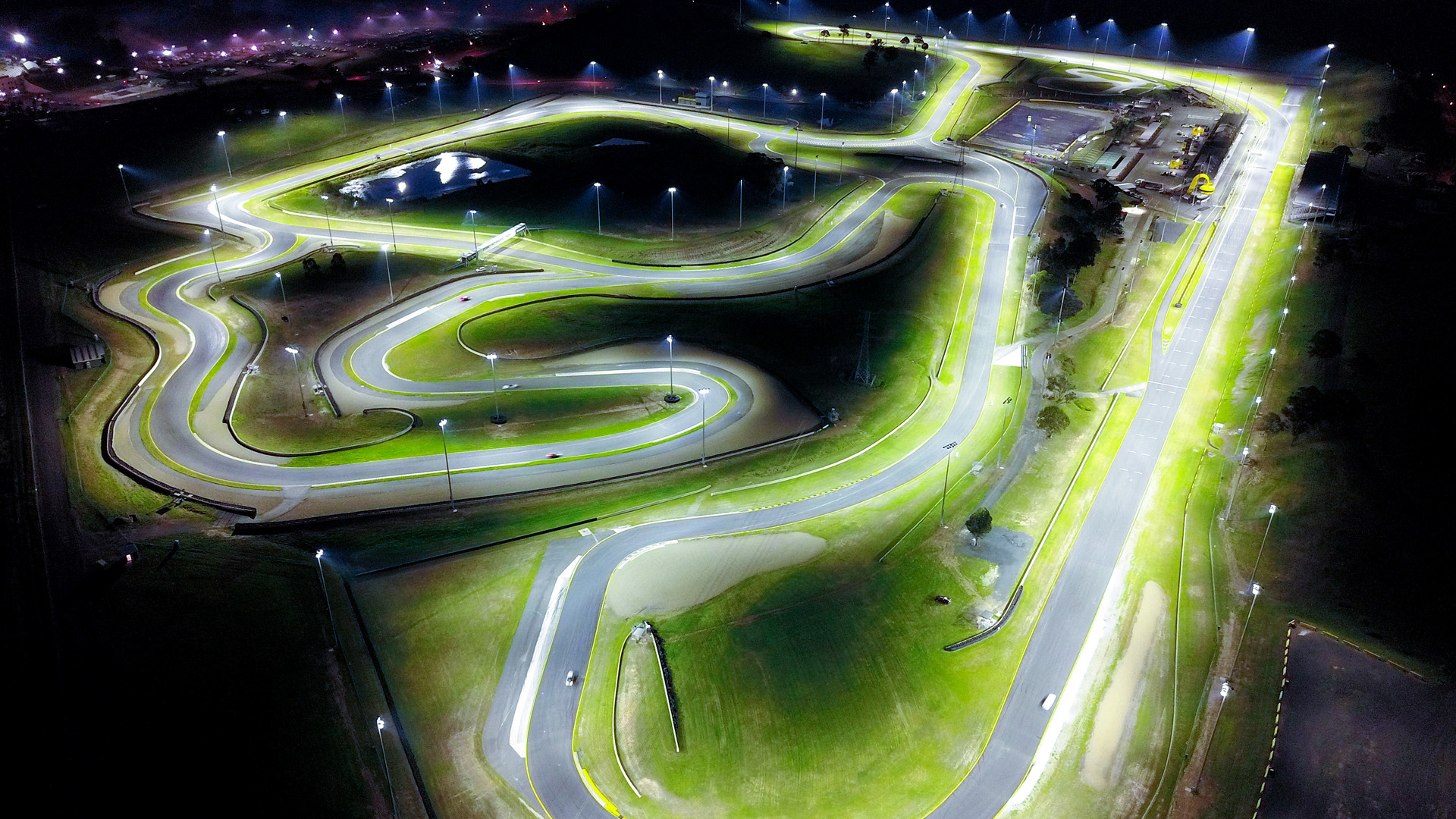 Racetrack at Sydney Motorsport Park is lit with Musco LED lighting while surrounding areas remain dark due to factory aimed lighting fixtures.