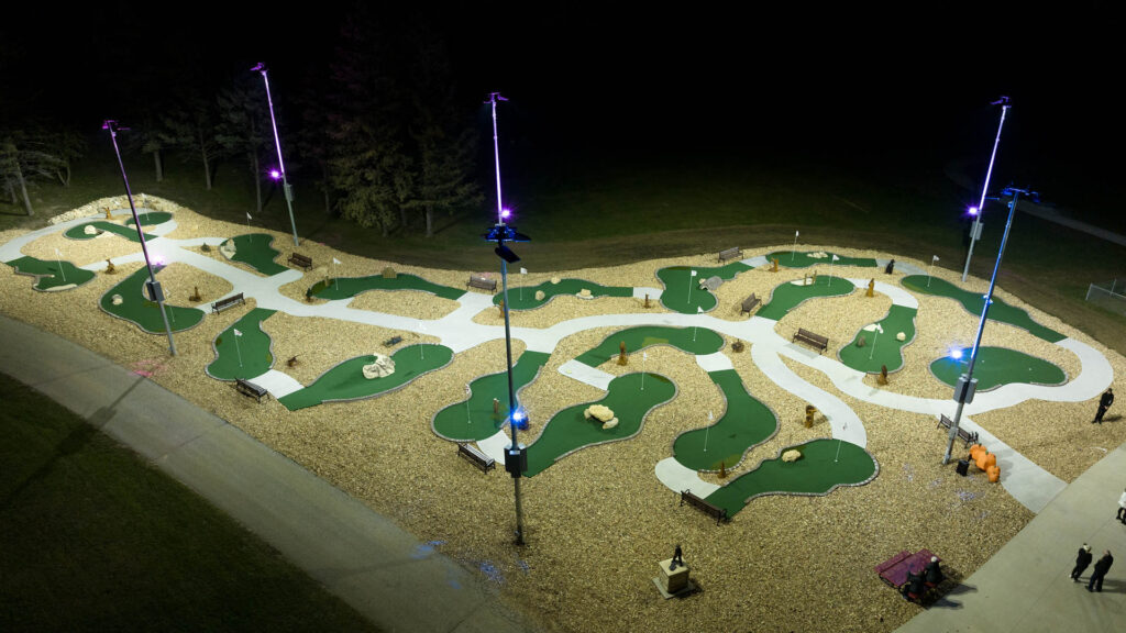 Accessible mini-golf course at Camp Courageous is lit at night with LED lights