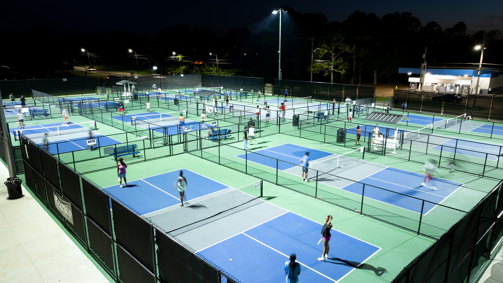 Visitors to Lee Acres' Dot Cooper Kelly Park play pickleball on course lit with DarkSky certified sports lighting.