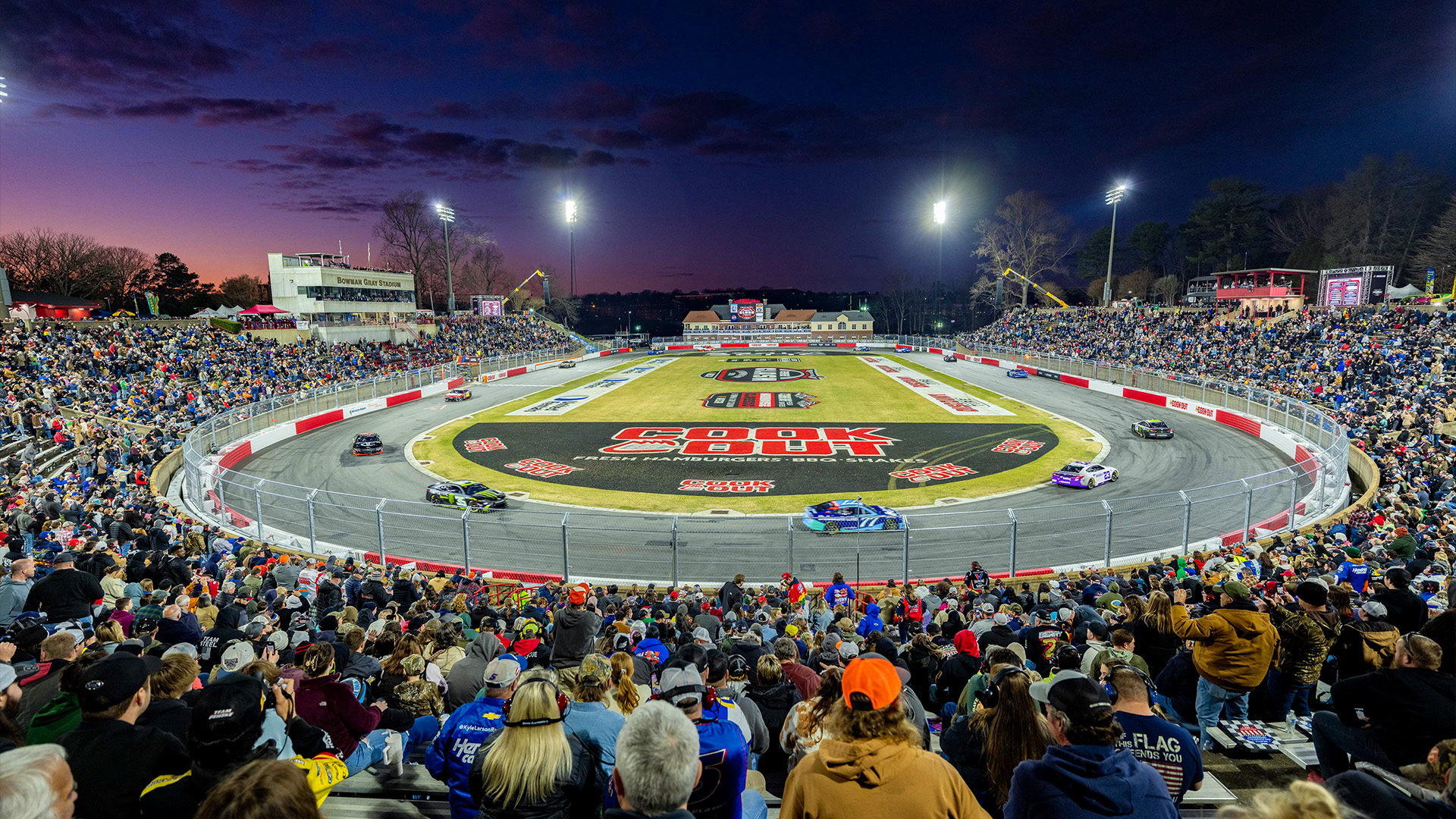 NASCAR fans watch night racing at Bowman Stadium with Musco mobile LED lighting in the background.
