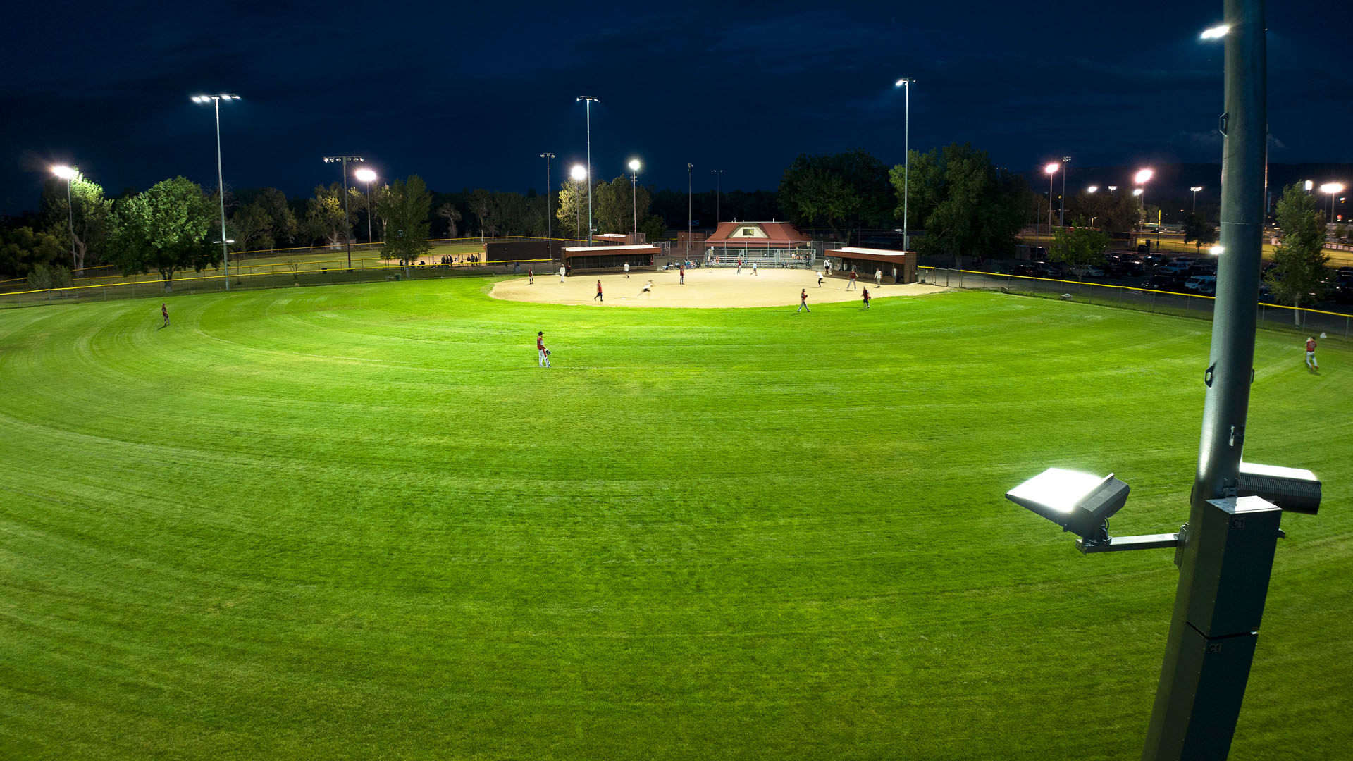 Community baseball field at night but lighted