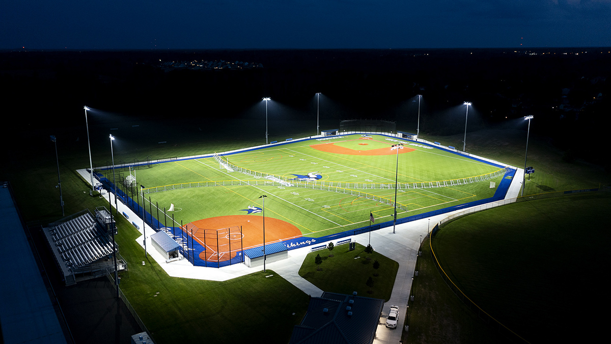 Multiple baseball fields with overhead lighting