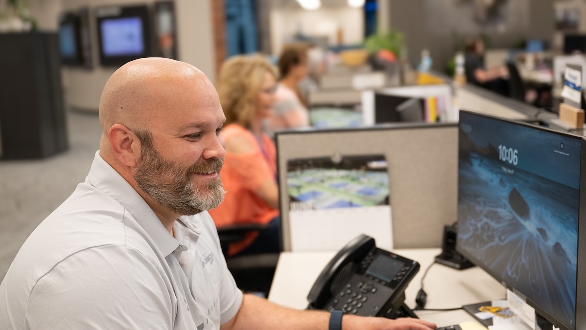man smiling while working at office desk