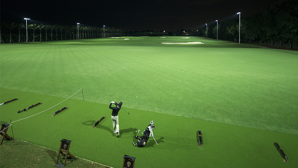 Driving range with one golfer with overhead lighting